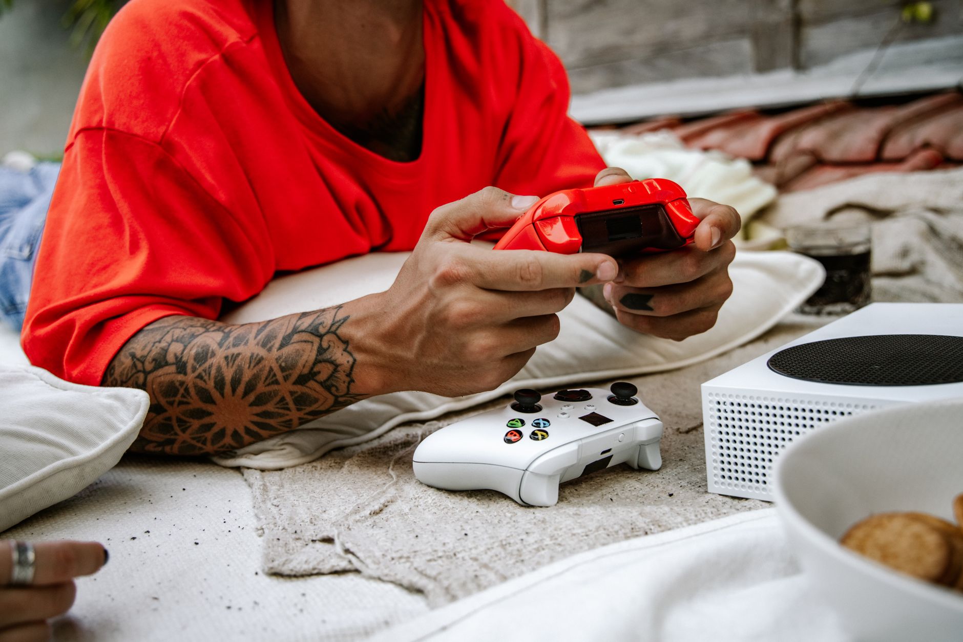 A person playing video games with a controller outdoors, showcasing leisure and technology.