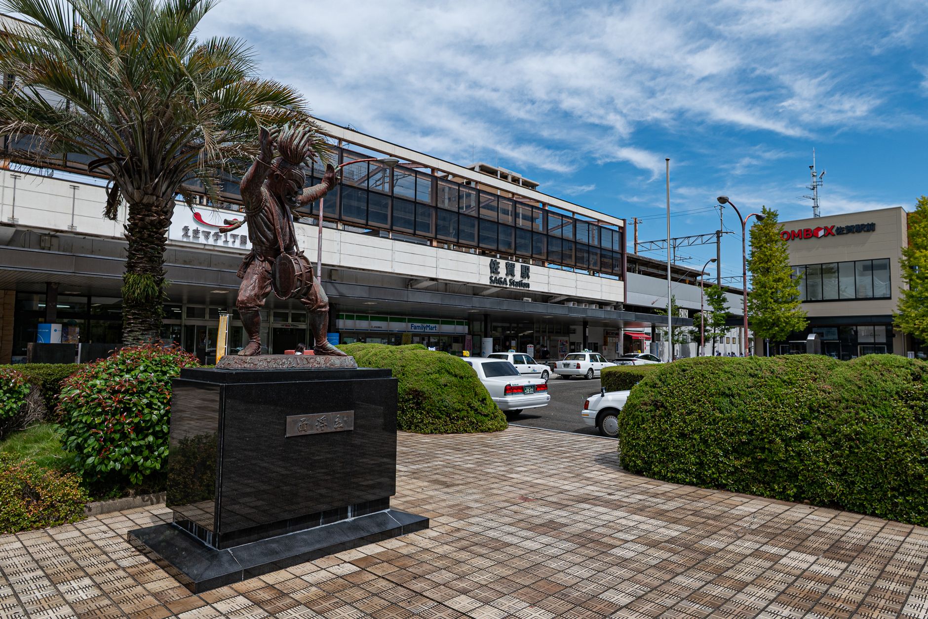 View of Saga Station in Saga, Japan with prominent sculpture in foreground.