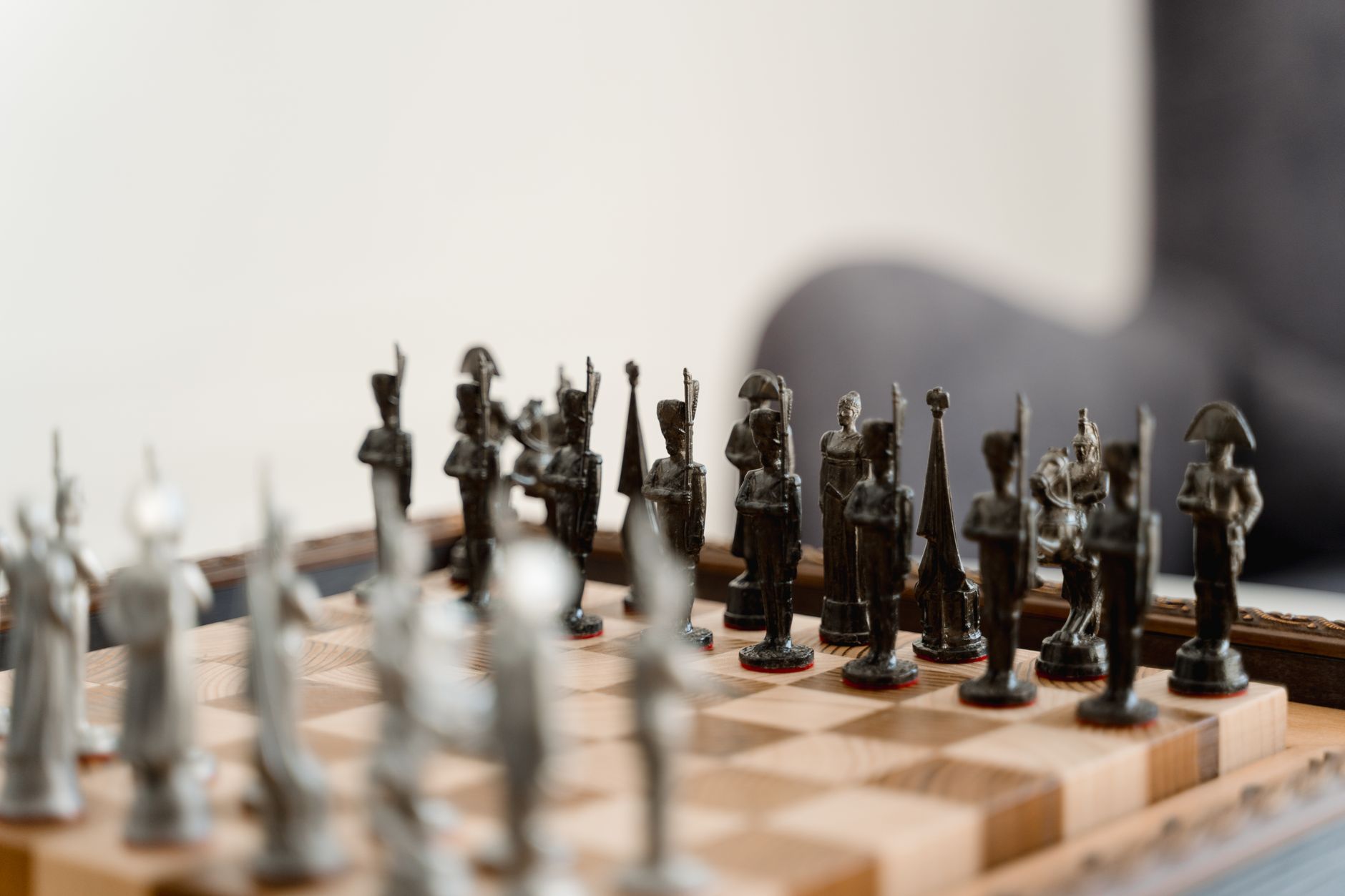 A close-up view of a chessboard with intricately designed metal chess pieces in focus.