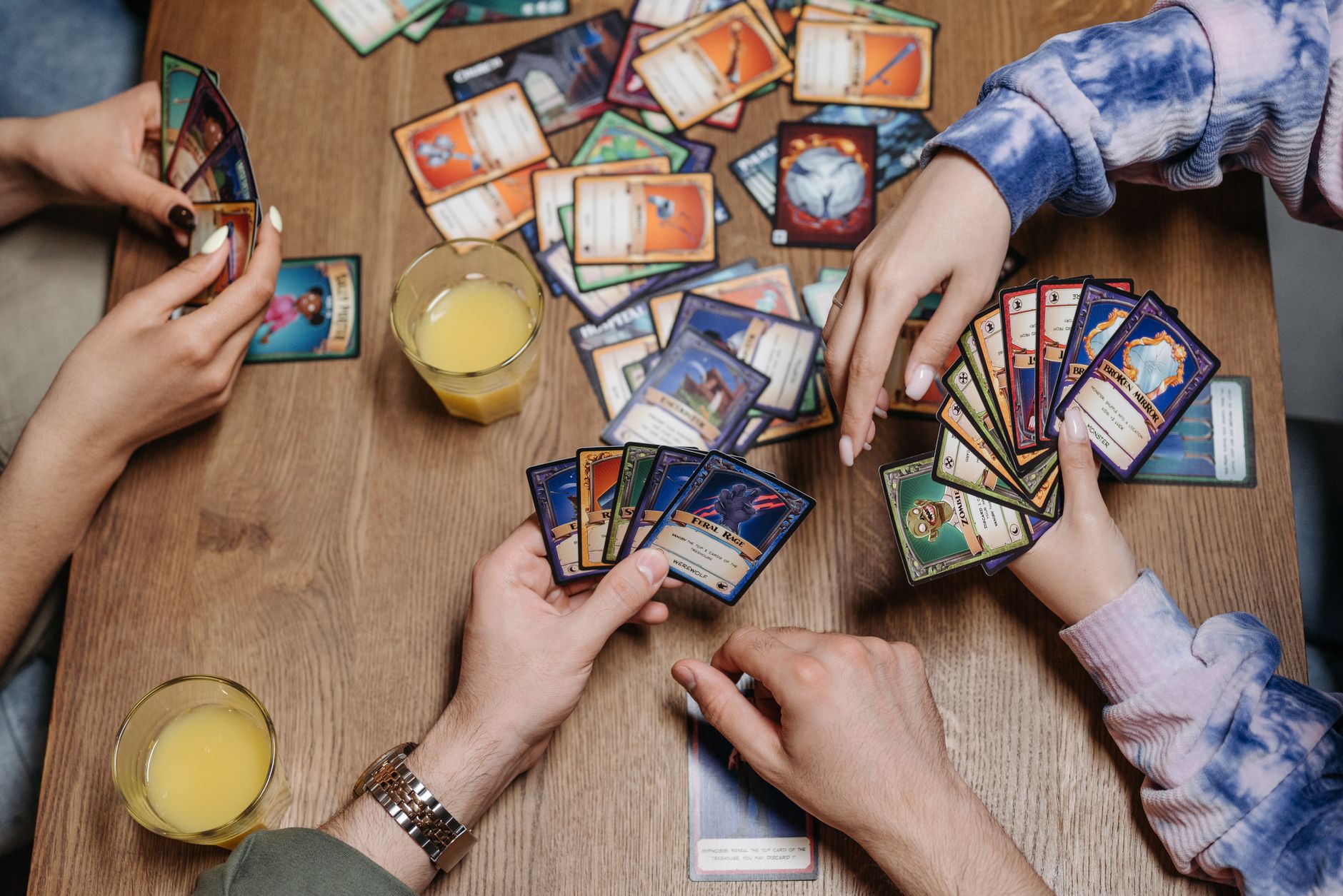Close-up of friends playing a card game at a table, fostering socialization and togetherness.