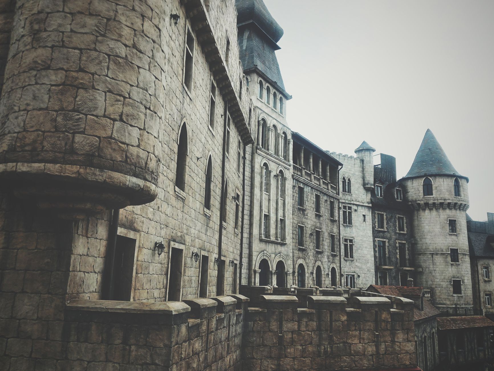 A medieval stone castle exterior with turrets and windows, creating a historic and mysterious atmosphere.