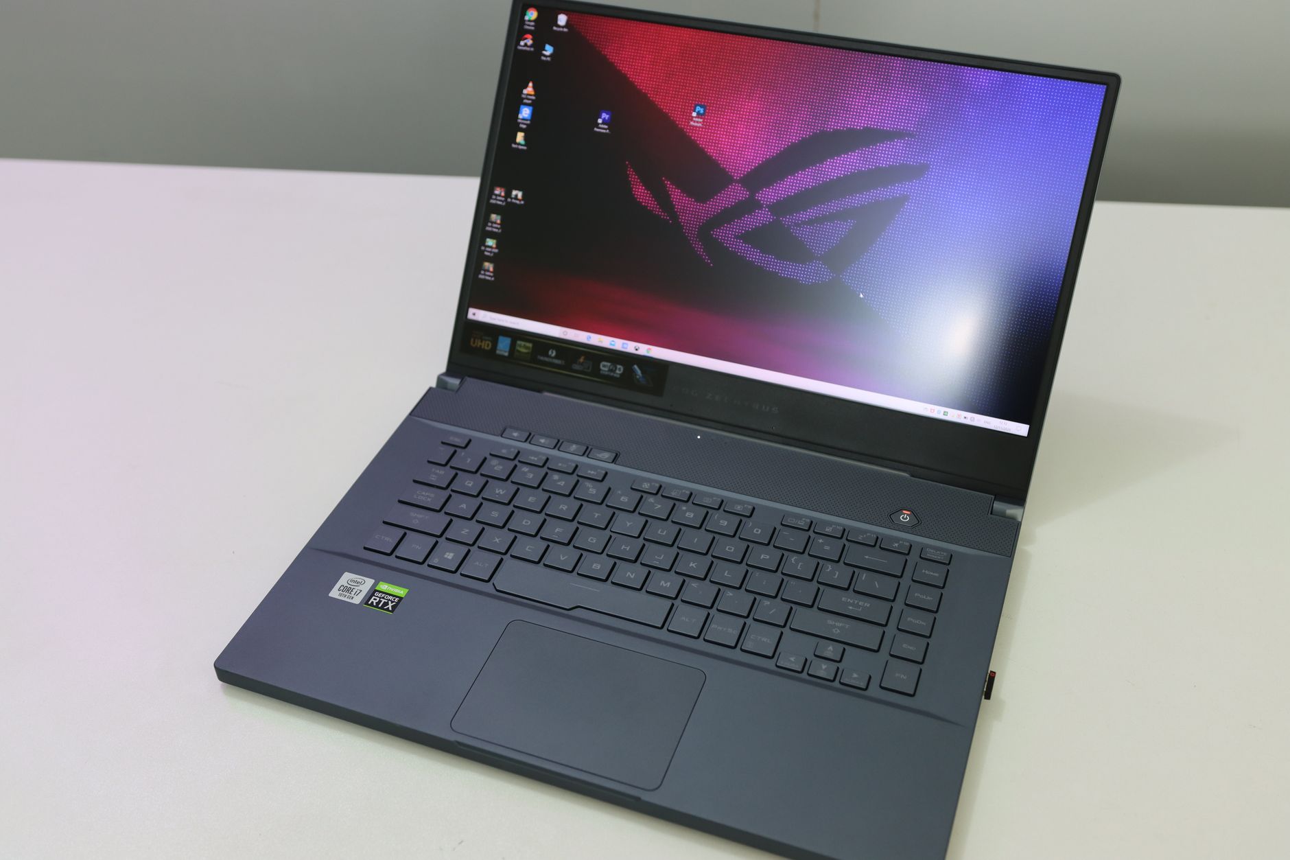 A sleek and modern laptop featuring a black keyboard on a white desk top, showcasing technology and design.