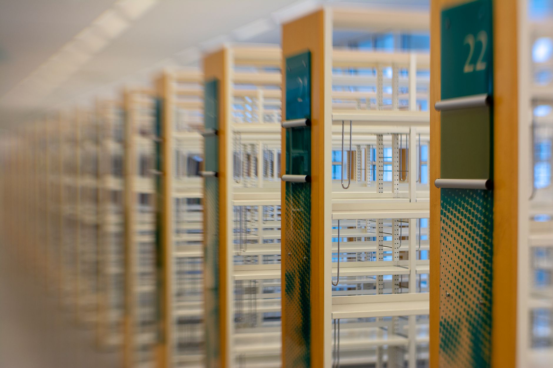 A modern library with rows of empty numbered bookshelves, offering a blurred perspective.