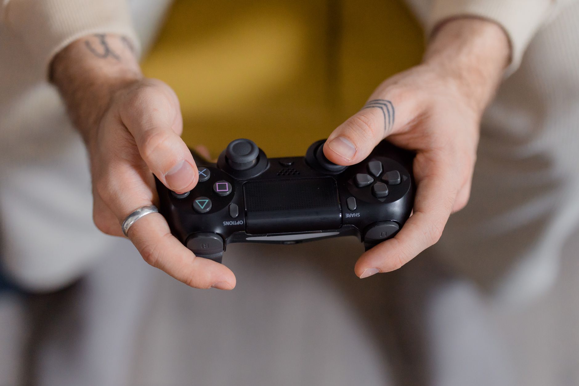A gamer holding a black game controller, focusing on gaming and entertainment.