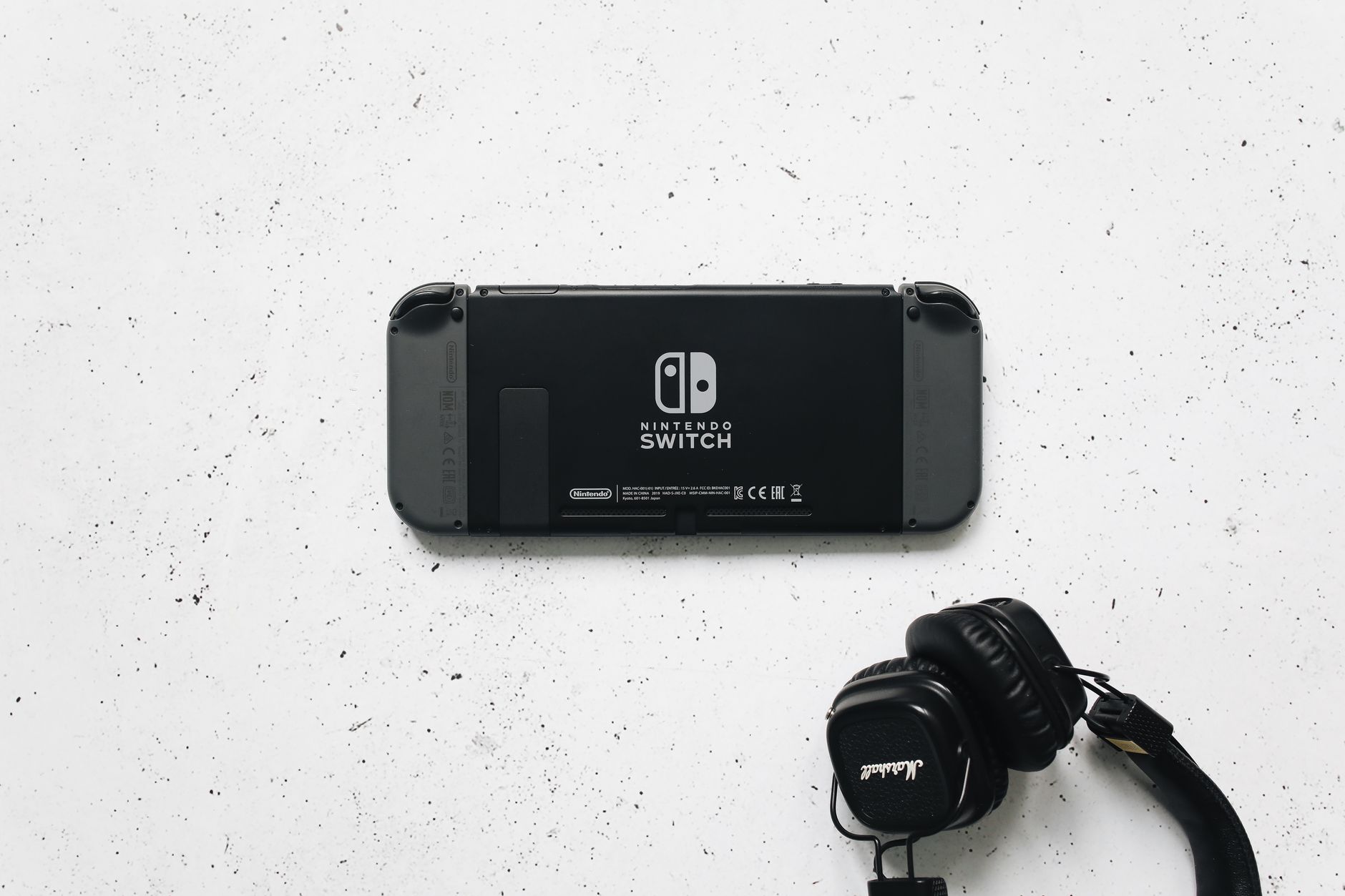 Nintendo Switch and headphones on a minimalist marble background, perfect for gaming content.