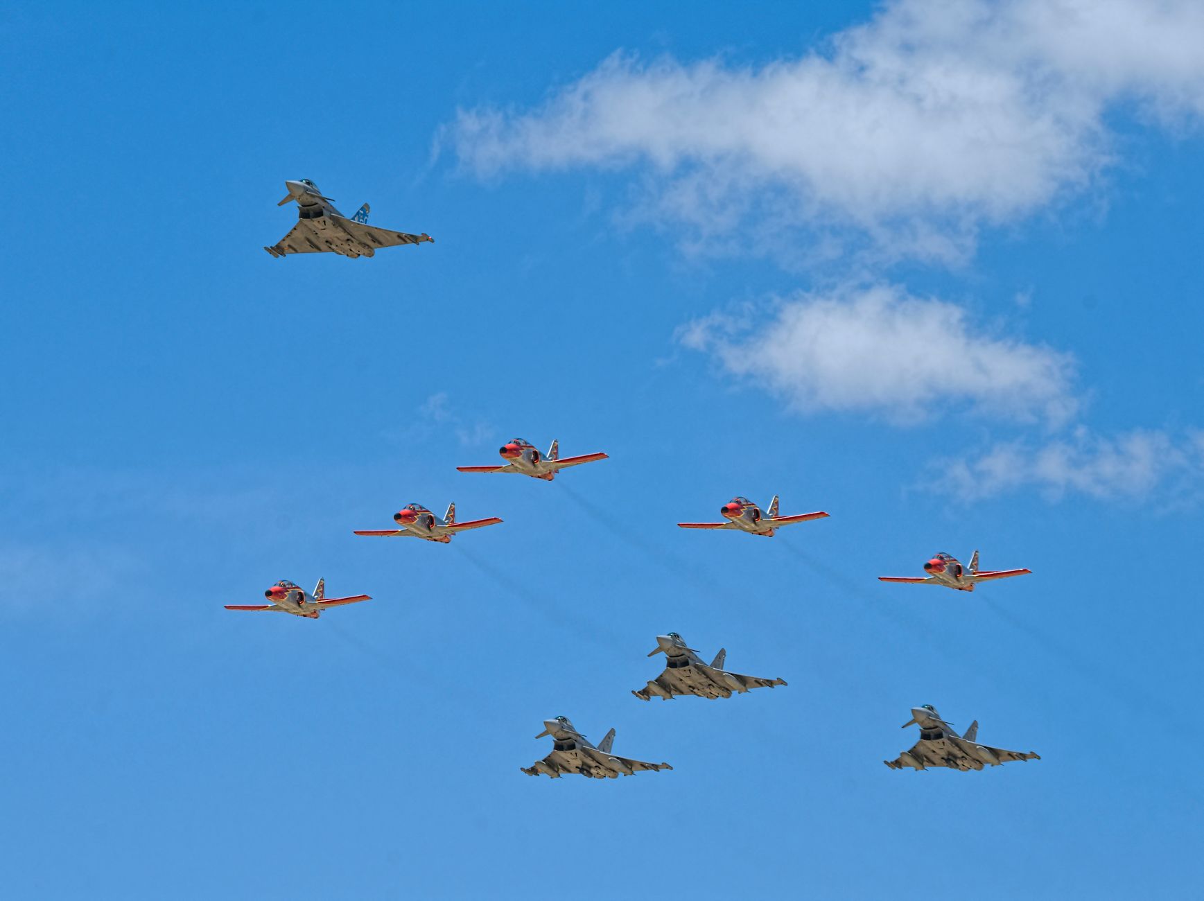 A stunning aerial display of military jets flying in formation against a clear blue sky.