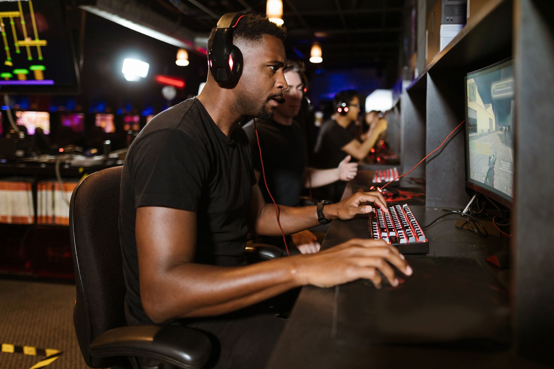 Group of gamers intensely focused on competitive eSports at a modern gaming arena.