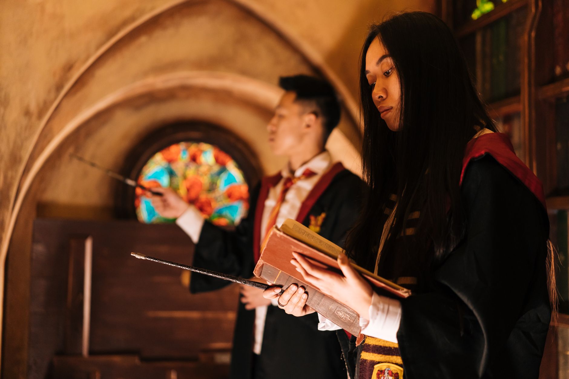 Young wizards practicing spells inside a magical setting with books and wands.